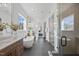 Elegant bathroom featuring a freestanding tub, double vanity, large mirrors, and modern lighting fixtures at 4800 Lakemont Dr, Raleigh, NC 27609