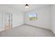 Bright, empty bedroom features a large window with a treed view and neutral carpet at 4800 Lakemont Dr, Raleigh, NC 27609