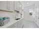 Well-lit laundry room with ample storage space, modern appliances, elegant tile flooring, and a window at 4800 Lakemont Dr, Raleigh, NC 27609