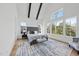 Large bedroom with vaulted ceiling, exposed beams, and many windows showcasing the wooded scenery at 4800 Lakemont Dr, Raleigh, NC 27609