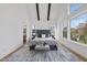Large bedroom with vaulted ceiling, exposed beams, and many windows showcasing the wooded scenery at 4800 Lakemont Dr, Raleigh, NC 27609