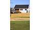 The backyard has a putting green and a house with a screened-in porch in the background at 818 Barbour Farm Ln, Four Oaks, NC 27524