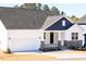 Attractive home with a two-car garage and covered front porch, showcasing a mix of siding and stone details at 818 Barbour Farm Ln, Four Oaks, NC 27524