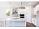 Well-lit kitchen boasting white cabinets, modern fixtures, stainless appliances, and a functional center island at 818 Barbour Farm Ln, Four Oaks, NC 27524