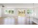 Bright and airy living room with hardwood floors, neutral walls, and a screened porch in the background at 818 Barbour Farm Ln, Four Oaks, NC 27524