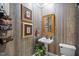 Stylish bathroom with pedestal sink, decorative wallpaper, and towel rack at 7220 Dime Dr, Raleigh, NC 27606