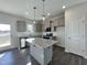 Modern kitchen with gray cabinets, granite island, and stainless steel appliances at 298 Springtooth Dr, Zebulon, NC 27597