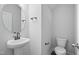 This bathroom features a round mirror above a pedestal sink, with gray walls and wood-look flooring at 808 Challenger Ln, Knightdale, NC 27545