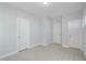 A bright bedroom featuring neutral carpeting and three doors at 808 Challenger Ln, Knightdale, NC 27545