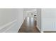 A long hallway with hardwood floors and decorative wainscoting leads to the main living area at 808 Challenger Ln, Knightdale, NC 27545