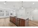 Modern kitchen island with quartz countertop, wood cabinets, and stainless steel sink at 448 Billingshurst Way, Knightdale, NC 27545