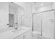 Bright bathroom with white cabinets, quartz countertop, chrome fixtures, and a glass shower door at 506 Billingshurst Way, Knightdale, NC 27545