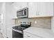 Close-up of a modern kitchen with stainless steel stove, microwave, and white countertops at 506 Billingshurst Way, Knightdale, NC 27545