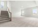 Unfinished basement with plush carpeting, staircase and natural light from multiple windows at 8905 Stratus St, Willow Springs, NC 27592