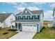 Charming two-story home featuring blue siding, black shutters and a two-car garage at 8905 Stratus St, Willow Springs, NC 27592