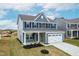 Charming two-story home featuring blue siding, black shutters, and a two-car garage at 8905 Stratus St, Willow Springs, NC 27592