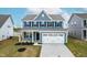 Charming two-story home featuring blue siding, black shutters, and a two-car garage at 8905 Stratus St, Willow Springs, NC 27592