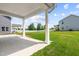 Covered back porch featuring white columns, concrete flooring, and a view of the grassy backyard at 8869 Tartan Clan Dr, Willow Springs, NC 27592