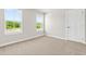 Bright bedroom with neutral carpet and two large windows overlooking the landscape at 8869 Tartan Clan Dr, Willow Springs, NC 27592