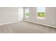 Inviting bedroom with neutral carpet, base trim, and two large windows providing ample light at 8869 Tartan Clan Dr, Willow Springs, NC 27592
