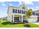Charming two-story home with a manicured lawn, two-car garage, and a welcoming front porch at 8869 Tartan Clan Dr, Willow Springs, NC 27592