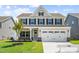 Beautiful two-story home featuring a two-car garage, landscaped front yard, and covered entryway at 8869 Tartan Clan Dr, Willow Springs, NC 27592