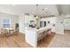 Bright, modern kitchen boasts white cabinets, a large island with seating, and stainless steel appliances at 8869 Tartan Clan Dr, Willow Springs, NC 27592