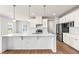 Modern kitchen with stainless steel appliances, island, and undermount lighting at 8869 Tartan Clan Dr, Willow Springs, NC 27592
