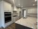 Modern kitchen featuring white cabinets, large center island, and stainless steel oven at 135 Ironwood Blvd # 49, Youngsville, NC 27596