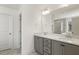 Modern bathroom with double vanity, grey cabinets and a large mirror at 18 Steppe Way, Garner, NC 27529