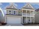 Two-story house with gray siding, white columns, and a two-car garage at 18 Steppe Way, Garner, NC 27529