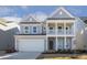 Two-story house with gray siding, white columns, and a two-car garage at 18 Steppe Way, Garner, NC 27529