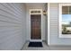 Dark brown front door with a sidelight and a black doormat at 18 Steppe Way, Garner, NC 27529