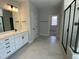 Modern bathroom featuring dual vanities, a glass-enclosed shower, and neutral tiling at 367 W Amber Oak Dr # 53, Selma, NC 27576
