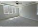 Sunlit bedroom with tray ceiling, complemented by soft carpeting, and multiple large windows at 367 W Amber Oak Dr # 53, Selma, NC 27576