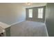 Open bonus room with neutral walls, plush carpeting, and two windows for plenty of natural light at 367 W Amber Oak Dr # 53, Selma, NC 27576