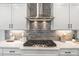 Close-up of a modern gas range and stylish backsplash in a well-lit kitchen at 367 W Amber Oak Dr # 53, Selma, NC 27576