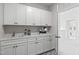 Well-organized laundry room featuring white cabinets, sink, and modern design at 367 W Amber Oak Dr # 53, Selma, NC 27576