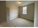 Cozy bedroom with neutral paint, carpeting, and a window providing natural light and a view of the outdoors at 399 W Amber Oak Dr # 52, Selma, NC 27576