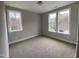 Well-lit bedroom featuring neutral walls, plush carpeting, and multiple windows offering natural light at 399 W Amber Oak Dr # 52, Selma, NC 27576