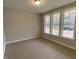 Bedroom with neutral carpet and large windows offering ample natural light and an outdoor view at 399 W Amber Oak Dr # 52, Selma, NC 27576