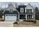 Beautiful two-story home featuring a covered front porch, an attached two-car garage, and manicured landscaping at 399 W Amber Oak Dr # 52, Selma, NC 27576