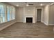 Open living room featuring a fireplace, large windows and vinyl floors at 399 W Amber Oak Dr # 52, Selma, NC 27576