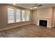 Open living room featuring a fireplace, ceiling fan, and a wall of windows showcasing the outdoor view at 399 W Amber Oak Dr # 52, Selma, NC 27576