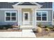 Inviting front porch with columns, a white front door, and manicured landscaping at 135 Newport Lndg, Garner, NC 27529