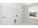 Clean laundry room with tile floors, a wire rack shelf, and window overlooking the neighborhood at 135 Newport Lndg, Garner, NC 27529