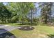 A gorgeous manicured backyard featuring lush green grass, mature trees, landscaping, and a stone patio at 14020 Durant Rd, Raleigh, NC 27614