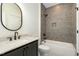 Modern bathroom with stylish gray tiling, sleek fixtures, and soaking tub at 14020 Durant Rd, Raleigh, NC 27614