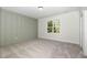 Well lit bedroom featuring a soothing accent wall and neutral carpet flooring at 14020 Durant Rd, Raleigh, NC 27614