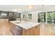 Open kitchen with a large island, stainless steel appliances, and access to the outdoor screened porch at 14020 Durant Rd, Raleigh, NC 27614